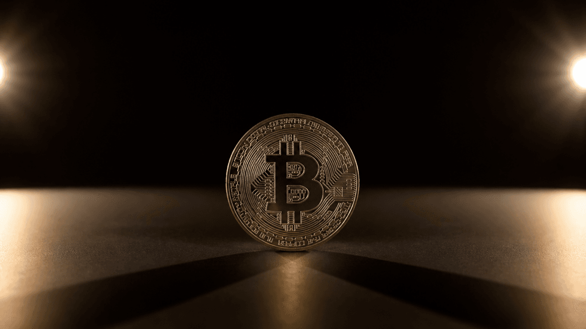 Aufrecht stehende Metallmuenze mit Bitcoin-Zeichen, die zwei identische Schatten in zwei verschiedene Richtungen wirft