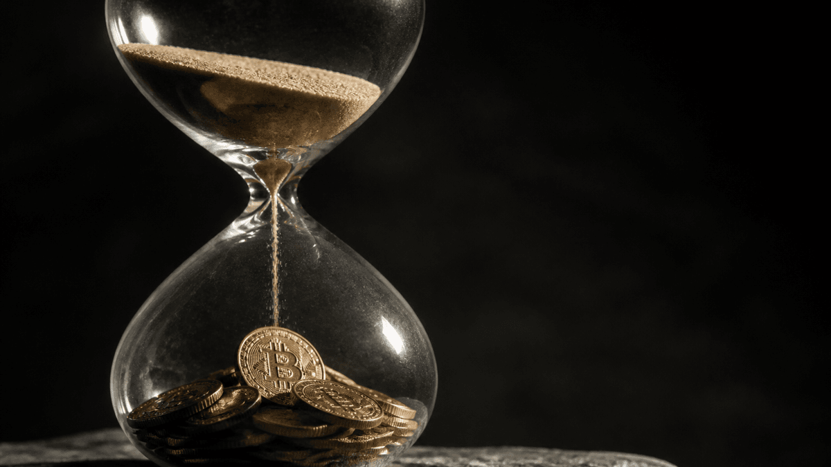 Sanduhr, in deren unterer Kammer sich statt Sand Metallmuenzen sammeln, eine davon mit Bitcoin-Symbol