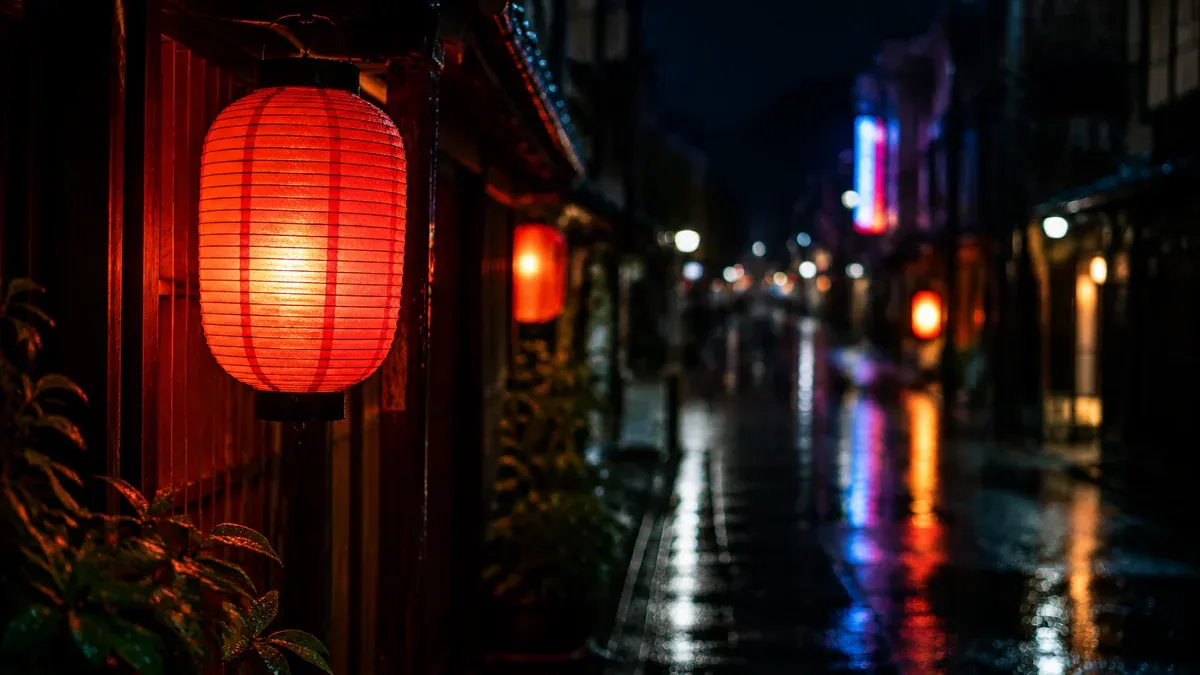 Nächtliche Seitenstraße in Tokio nach dem Regen mit Laternen und Spiegelungen