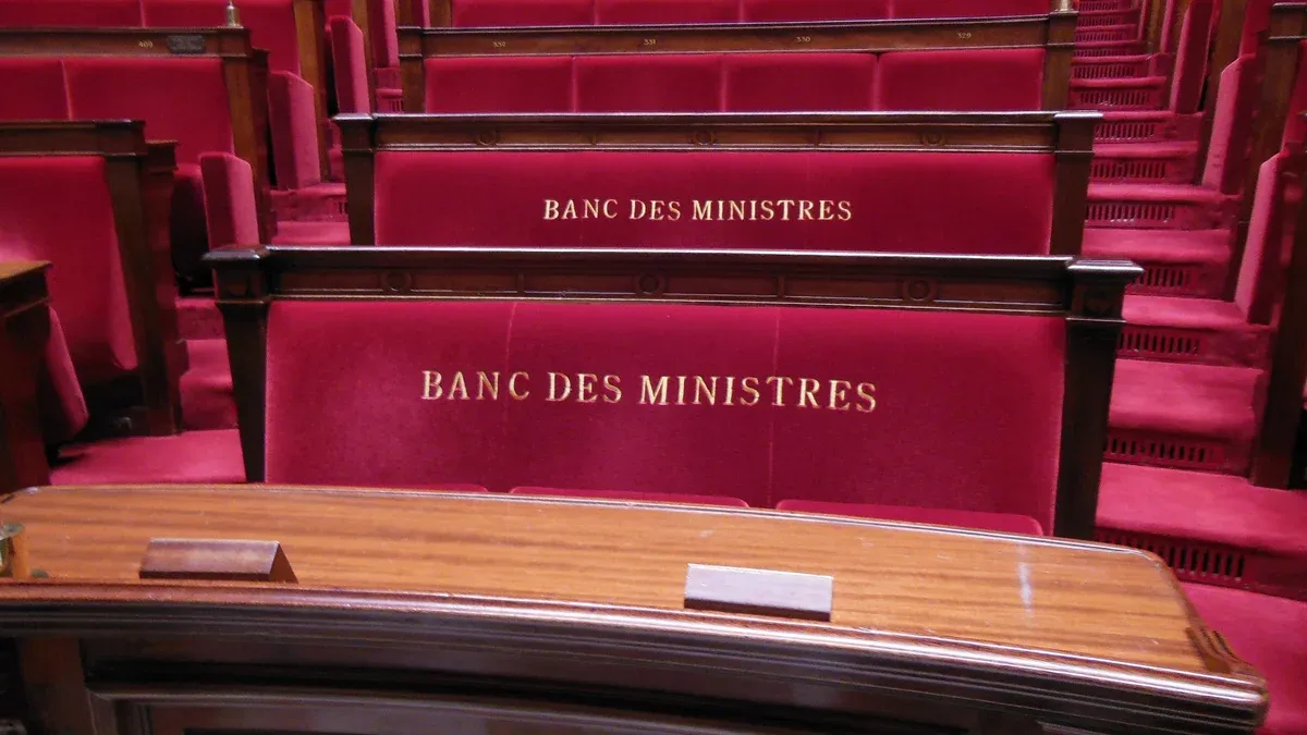 Rote Samtbänke mit der goldenen Aufschrift Banc des ministres im Plenarsaal der französischen Nationalversammlung
