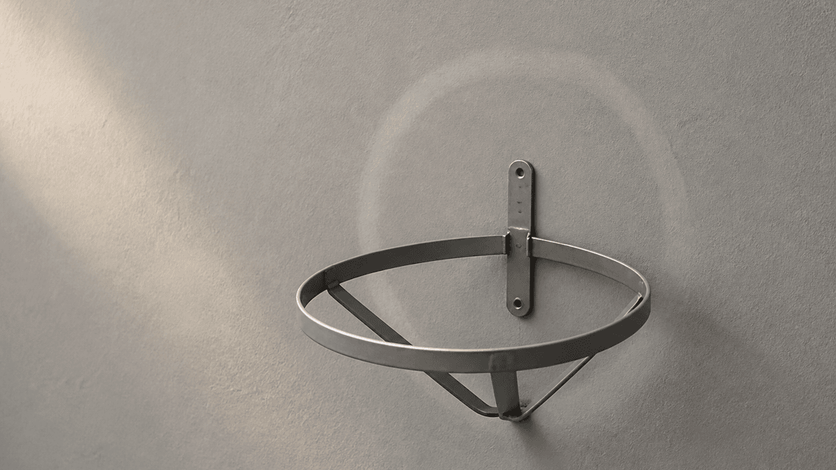 Leere blanke Wandhalterung aus Metall fuer einen Rettungsring an einer schlichten Wand