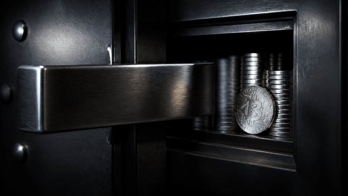 Steel bolt sliding across a vault compartment holding stacked silver coins and a coin with a Bitcoin symbol