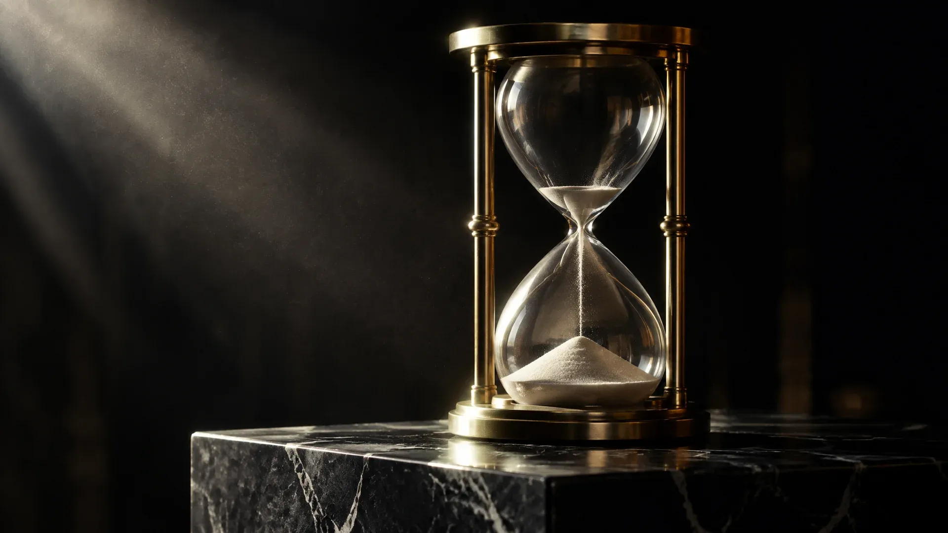 Große Sanduhr aus Messing und Glas auf einem Bankschalter aus dunklem Marmor, die obere Kammer fast leer